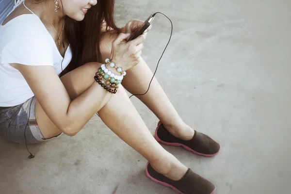 Woman listening to music on earphone with smart phone — Stock Photo, Image