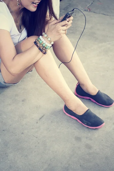 Mujer escuchando música en auriculares con teléfono inteligente —  Fotos de Stock