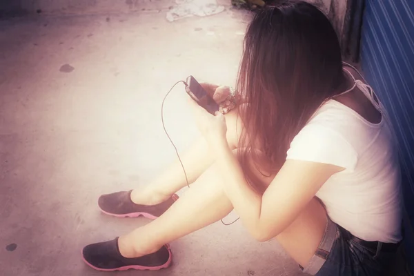 Mujer escuchando música en auriculares con teléfono inteligente —  Fotos de Stock