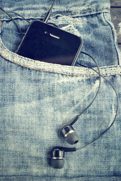 Auriculares y smartphone con jeans — Foto de Stock