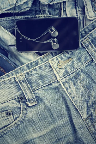 Auriculares y smartphone con jeans — Foto de Stock