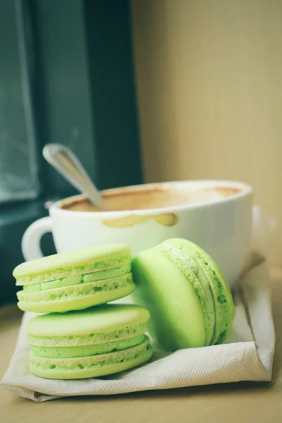 Macaroons verdes com xícara de café — Fotografia de Stock