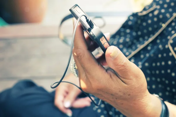 Senior listening to music on earphone with smart phone — Stock Photo, Image