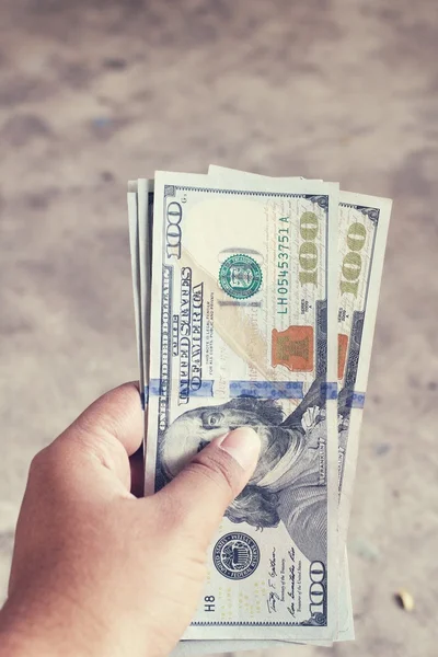 Dólares com mão — Fotografia de Stock
