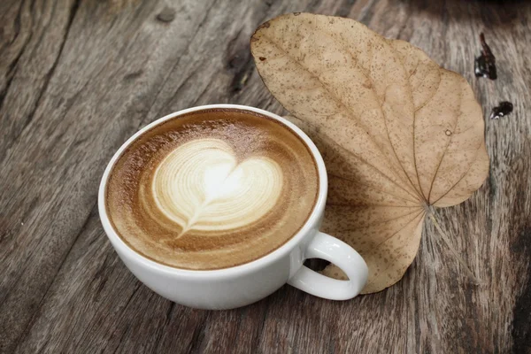 Vintage latte art kaffe med torkade blad — Stockfoto