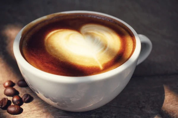 Vintage latte art coffee with shadow — Stock Photo, Image