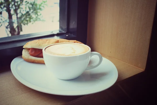 Vintage latte coffee with fast food hot dog — Stock Photo, Image