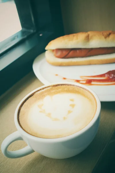 Vintage latte coffee with fast food hot dog — Stock Photo, Image