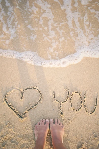 Селфи со словом heart вы написали на песке на пляже — стоковое фото