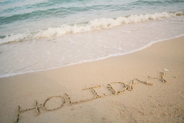 ビーチで砂で書かれた単語休日 — ストック写真