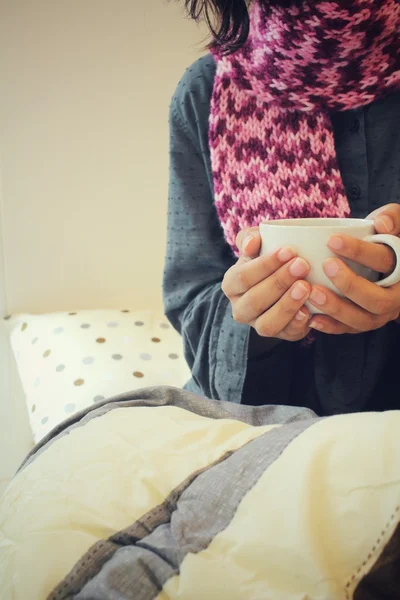 Kobieta pije kawy siedząc na łóżku — Zdjęcie stockowe