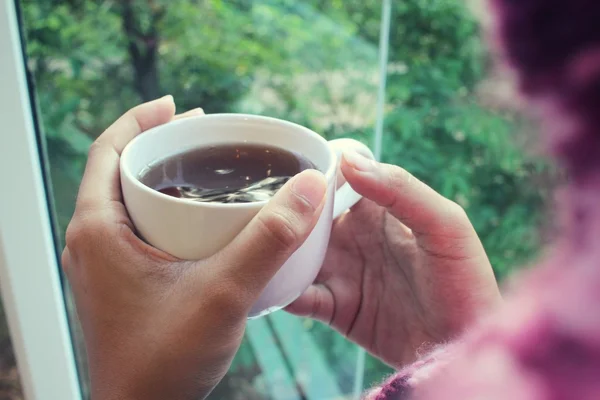 Woman drinking coffee cup near window in coffee shop — Stock Photo, Image