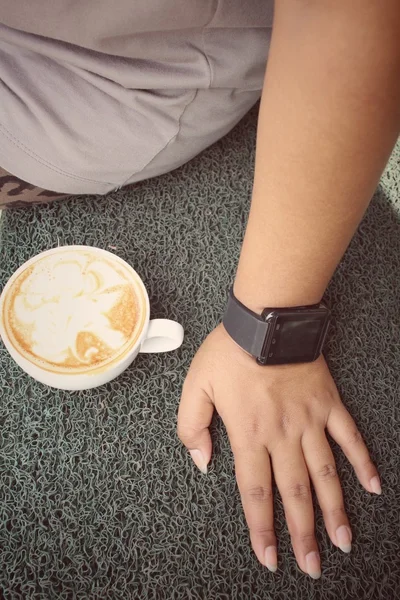 Frau trinkt Kaffee mit Smartwatch — Stockfoto