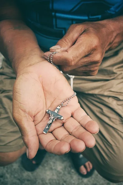 Mani anziane che pregano con croce — Foto Stock