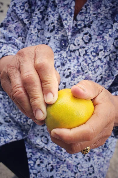 Äldre kvinna äta apelsin frukt — Stockfoto
