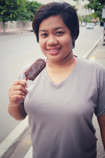Mulher comendo gelado de picolé de chocolate — Fotografia de Stock