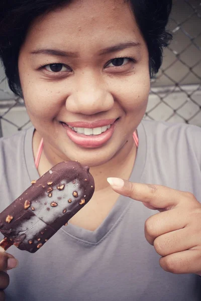 Donna che mangia ghiacciolo al cioccolato pop — Foto Stock