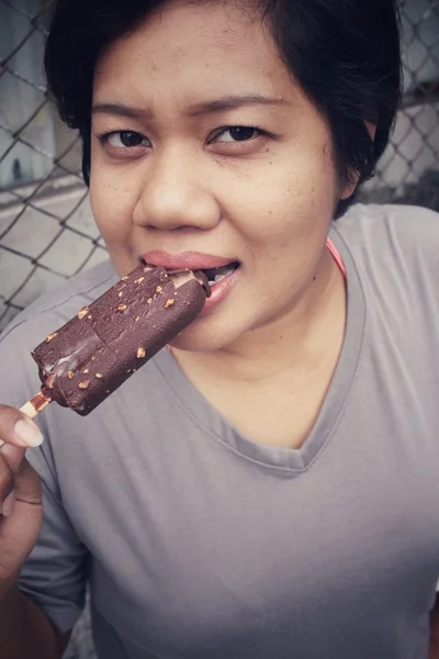 Mulher comendo gelado de picolé de chocolate — Fotografia de Stock