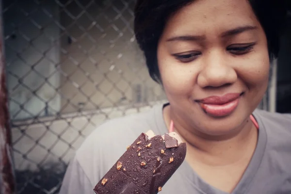Frau isst Eis am Stiel aus Schokolade — Stockfoto