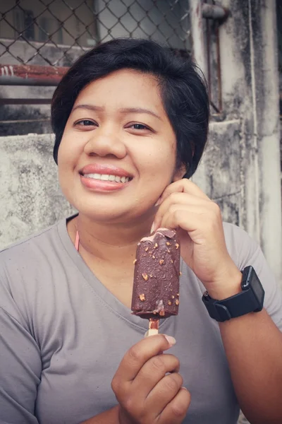 Mulher comendo gelado de picolé de chocolate — Fotografia de Stock