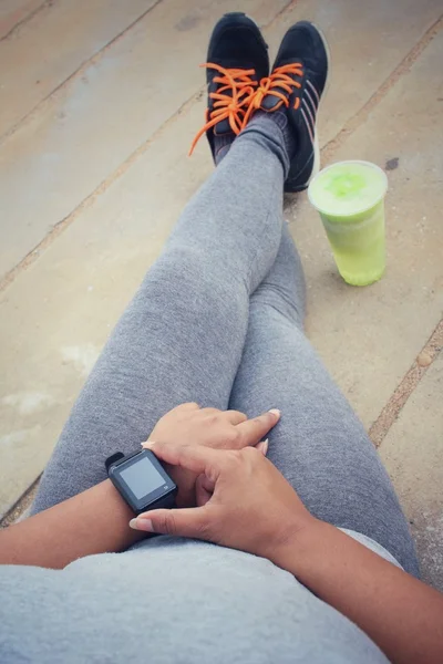 Zapatilla de correr mujer y smartwatch con batido de verduras verdes . — Foto de Stock