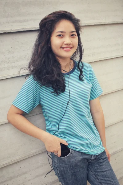 Mujer joven escuchando música en auriculares con teléfono inteligente — Foto de Stock