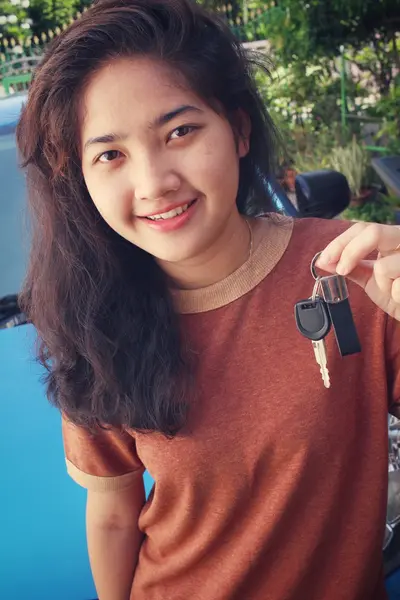 Mujer joven sosteniendo las llaves de un coche nuevo —  Fotos de Stock