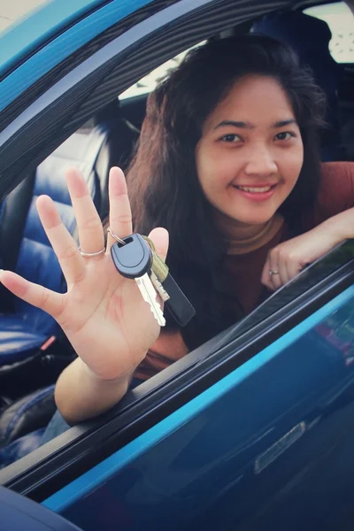 Ung kvinna innehar nycklarna till nya bil — Stockfoto