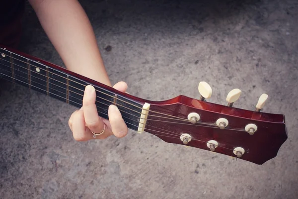 Ung kvinne som spiller gitar – stockfoto
