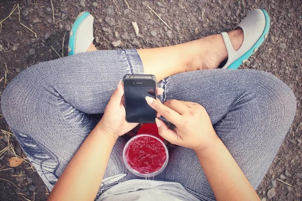 Nainen juo mansikka juoda älypuhelimella — kuvapankkivalokuva