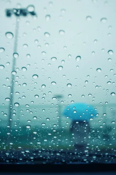 Розмиті краплі води з парасолькою — стокове фото