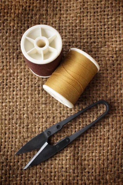 Sewing threads with scissors on sackcloth — Stock Photo, Image