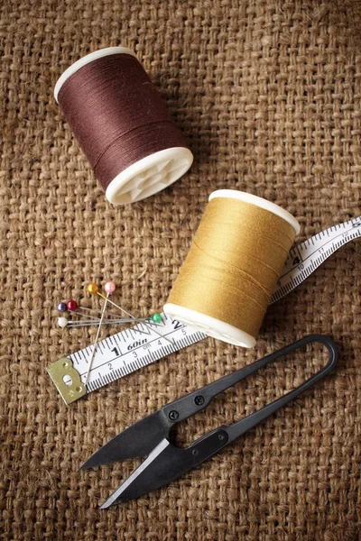 Hilos de coser con tijeras en tela de saco — Foto de Stock
