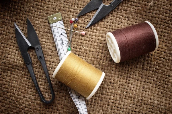 Hilos de coser con tijeras en tela de saco — Foto de Stock