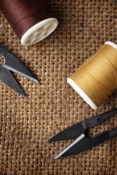 Hilos de coser con tijeras en tela de saco — Foto de Stock