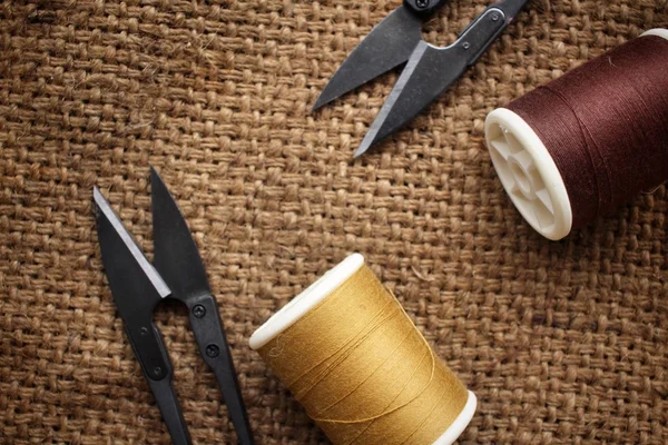 Hilos de coser con tijeras en tela de saco — Foto de Stock