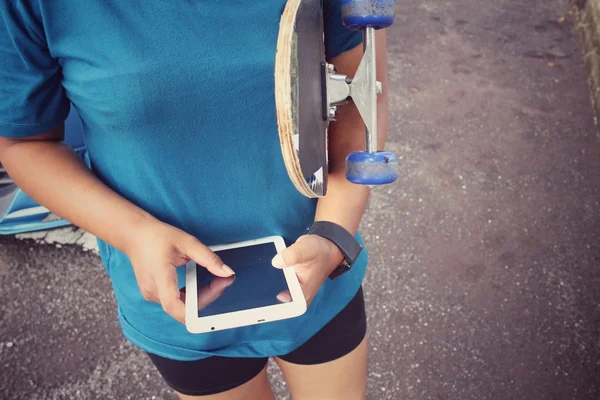 Menina usando tablet com skate — Fotografia de Stock