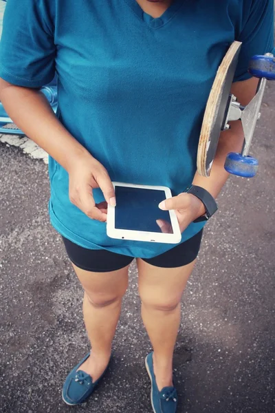 Menina usando tablet com skate — Fotografia de Stock