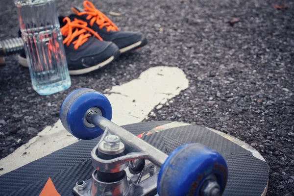 Skateboard sneakers en water drinken — Stockfoto