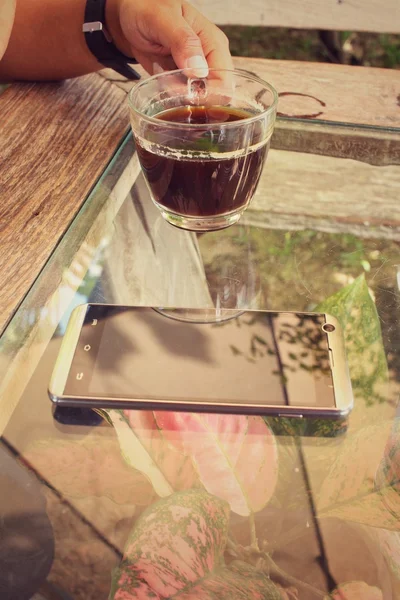 Mujer bebiendo café con teléfono inteligente — Foto de Stock