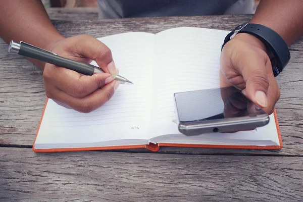 Kalem kağıt ve akıllı telefon yazılı olan kadın