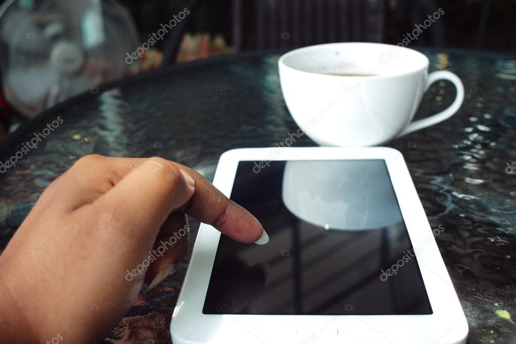Woman drinking hot coffee with tablet