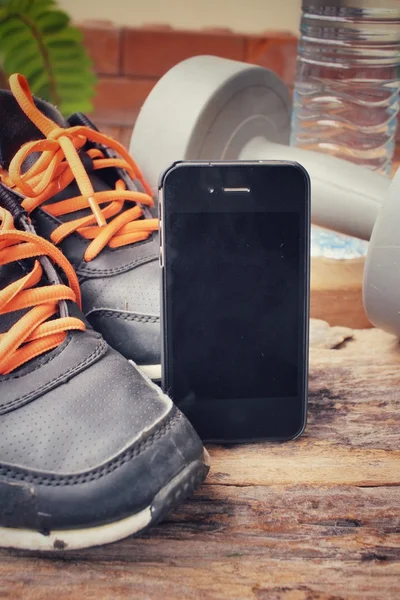 Conjunto deportivo de zapatillas, mancuernas, bebida de agua y teléfono inteligente — Foto de Stock