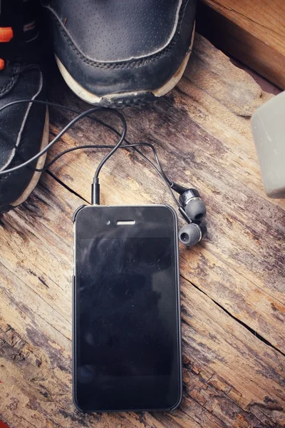 Jogo de esportes de tênis, fones de ouvido, telefone inteligente e dumbblell — Fotografia de Stock