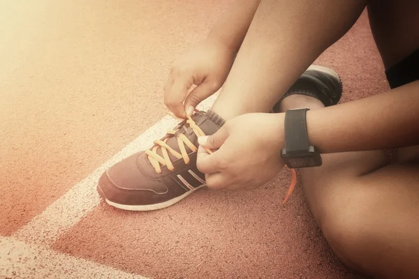 Mujer manos atando cordones de zapatos con smartwatch — Foto de Stock