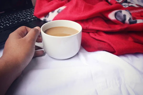 ベッドの上のコーヒー カップをもつコンピューター ノート — ストック写真