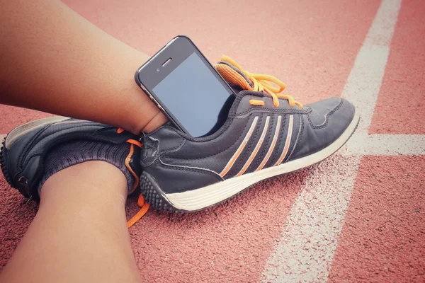 Yolda akıllı telefon ile spor ayakkabı