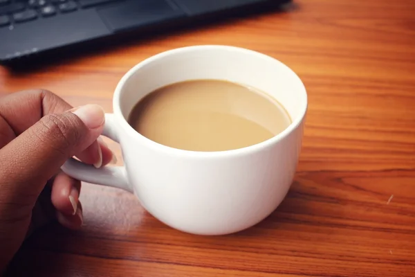 Кофейная чашка с ноутбуком в офисе — стоковое фото