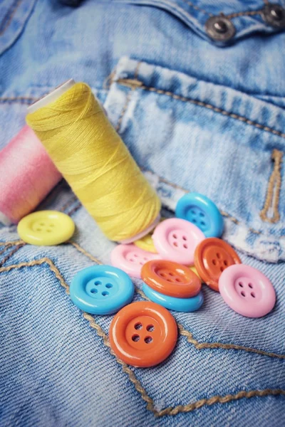 Tlačítka barevných šicích nití na džíny — Stock fotografie