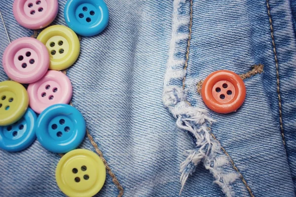 Красочные кнопки для шитья на джинсах — стоковое фото